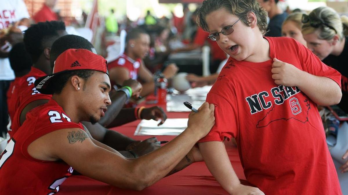 
Noah Kelly, 12, of Raleigh gets his t-shirt signed by Wolfpack safety Kalen McCain, Sunday, August 9, 2015 at Carter-Finley Stadium in Raleigh, N.C. during the Meet the Pack event.
