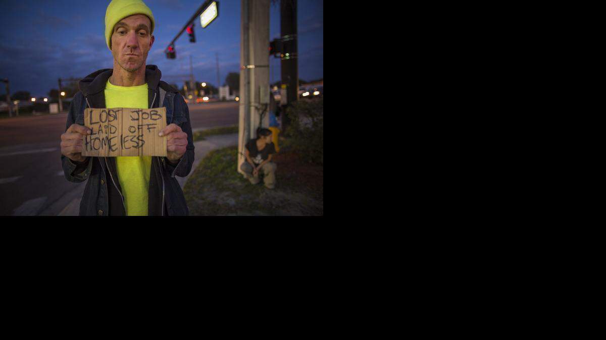 
Ryan Hoffman holds a panhandling sign in Lakeland, Fla. Hoffman, renowned for his toughness and durability, is now plagued with short-term memory problems and lives on the street, sometimes begging for money from passing cars.
