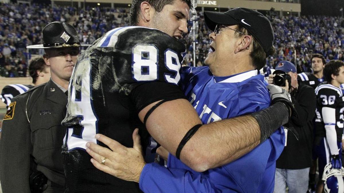 
In this Nov. 16, 2013, file photo, Duke coach David Cutcliffe, hugs Braxton Deaver (89) following an NCAA college football game against Miami in Durham. Deaver had surgery on his right ACL last Aug. 25th – he had torn his left one two years earlier – so that put him at feeling 100 percent ready to go in late June. And Wednesday brought another milestone in his recovery: the beginning of his final preseason camp.



