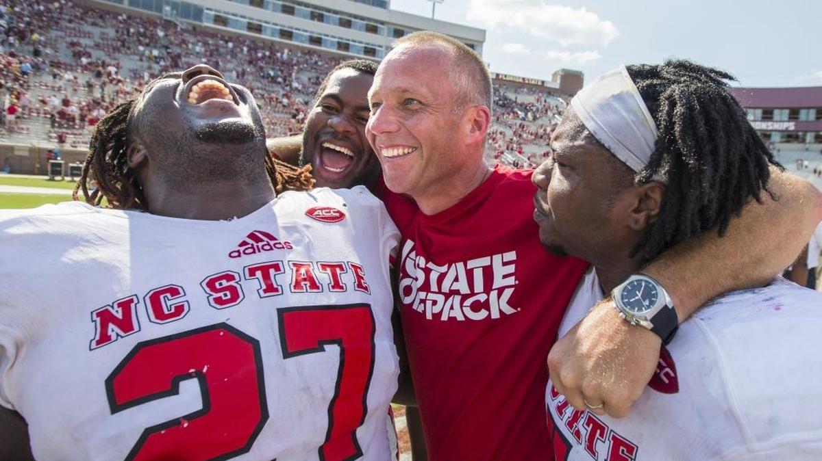 North Carolina State players, from left, Dakwa Nichols (27), defensive tackle B.J. Hill, head coach Dave Doeren and linebacker Jerod Fernandez celebrate defeating Florida State 27-21 in an NCAA college football game in Tallahassee, Fla., Saturday, Sept. 23, 2017. (AP Photo/Mark Wallheiser)