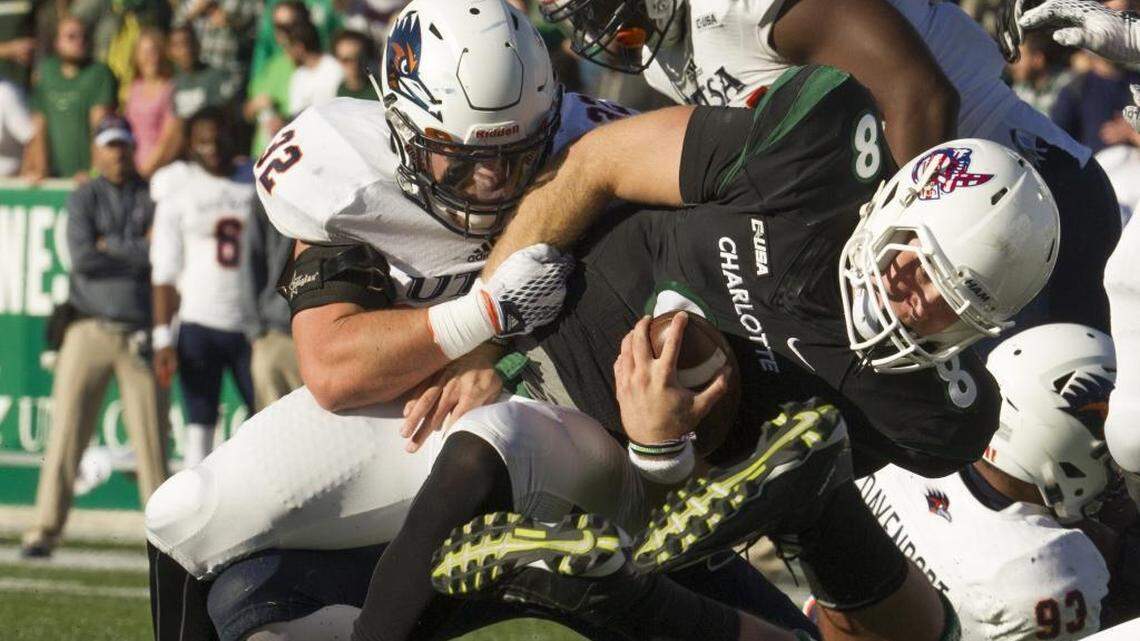 Charlotte 49ers quarterback Matt Johnson (8) gets caught by UTSA defenders Drew Douglas (32) and Kevin Strong, Jr. (54) during a college football game Saturday.