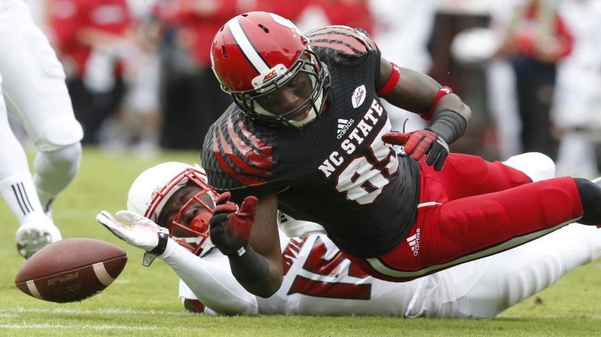 
N.C. State's Jumichael Ramos (85) fumbles while being hit by Louisville cornerback Trumaine Washington (15) during the first half. Louisville would recover the fumble.
