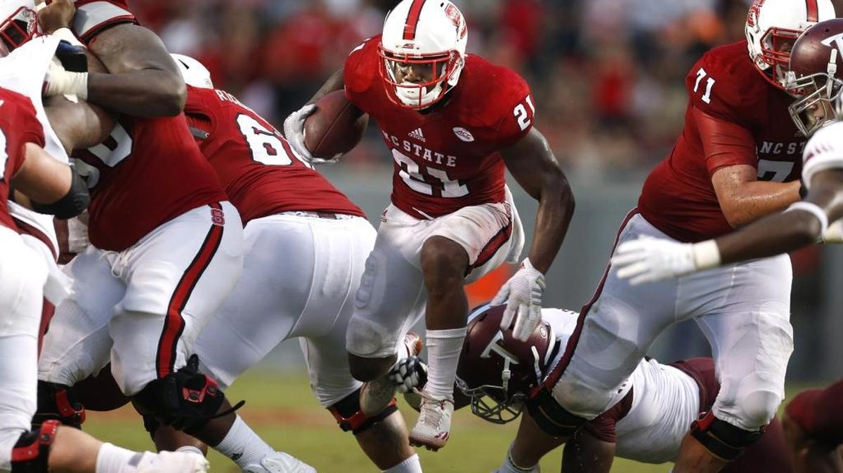 
N.C. State running back Matt Dayes (21) escapes a Troy defender during the first half of the Wolfpack's game against Troy at Carter-Finley Stadium in Raleigh, Saturday, Sept. 5, 2015. 
