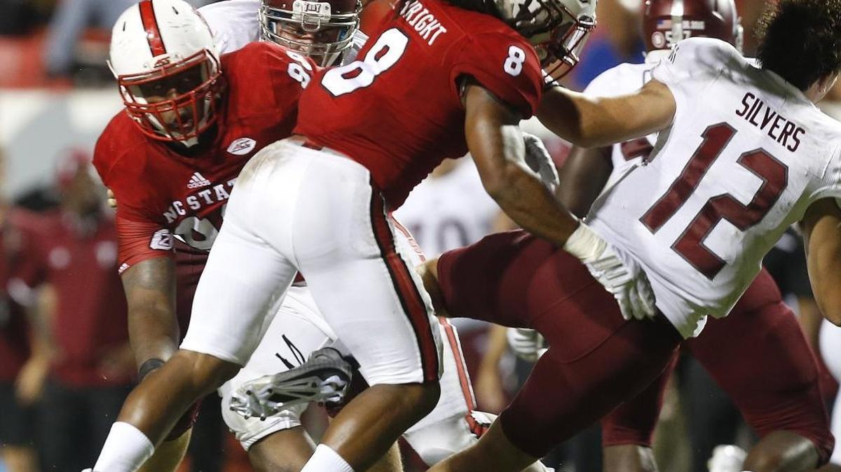 
N.C. State defensive back Dravious Wright (8) hits Troy quarterback Brandon Silvers (12), causing him to fumble  at Carter-Finley Stadium in Raleigh Saturday.
