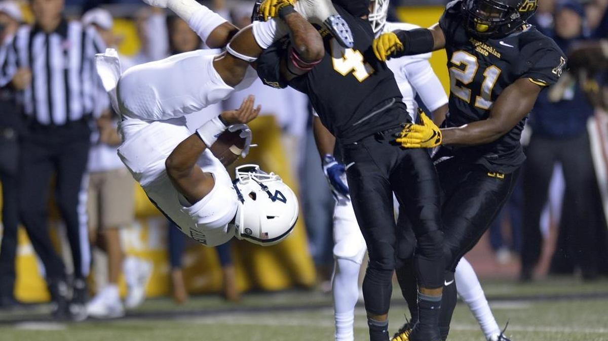 Appalachian State defensive back Mondo Williams (4) upends Georgia Southern quarterback Kevin Ellison, left, as Ellison scores a touchdown during the first quarter of an NCAA college football game at Kidd Brewer Stadium in Boone on Thursday.