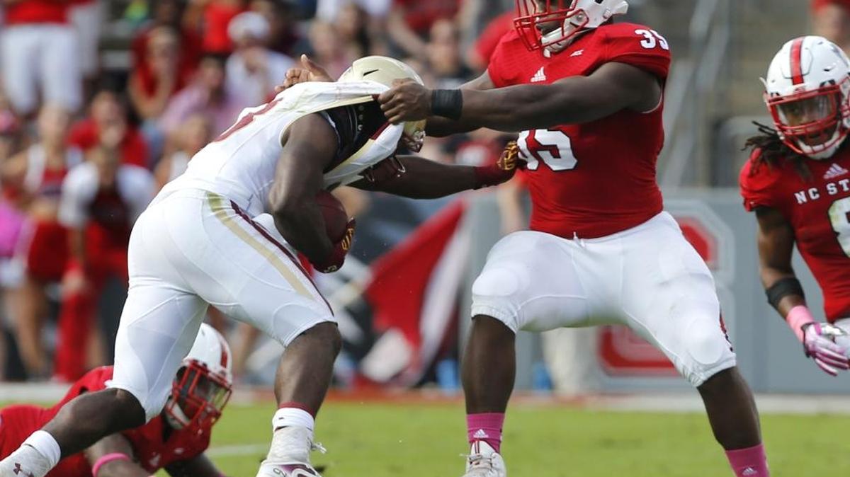 
N.C. State's Kentavius Street (35) tackles Boston College's Myles Willis (23) during the first half of the Wolfpack's game against Boston College at Carter-Finley Stadium in Raleigh, N.C., Saturday, October 11, 2014. 
