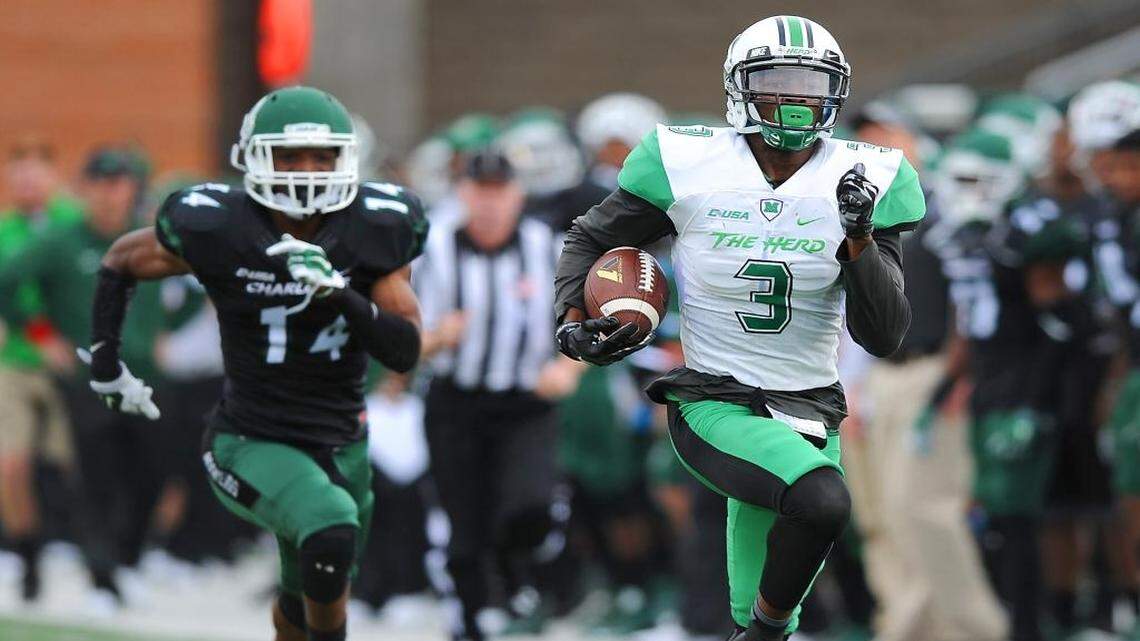 Marshall wide receiver Davonte Allen races into the end zone for a touchdown following a pass reception from quarterback Chase Litton during first-quarter action. Charlotte 49ers defensive back Tank Norman follows at McColl-Richardson Field at Jerry Richardson Stadium on Saturday.