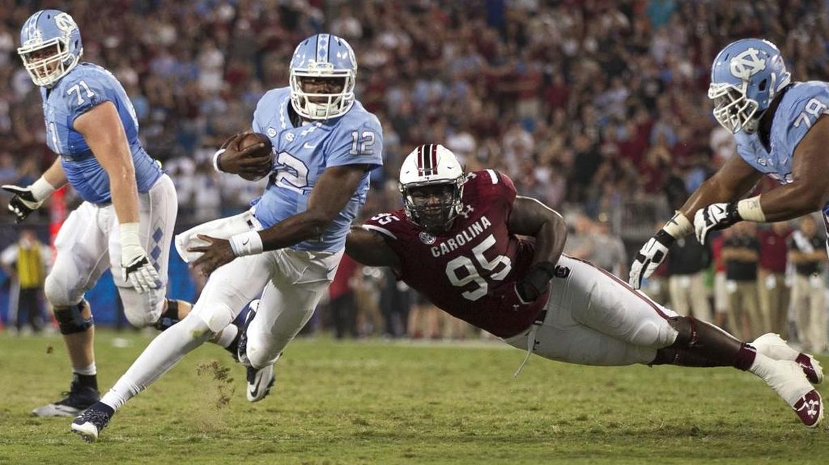 
North Carolina quarterback Marquise Williams (12) is slowed by South Carolina's Dante Sawyer (95) and sacked by the South Carolina defense for a 6-yard loss on the Tar Heels’ final drive of the game late in the fourth quarter in the Belk College Kickoff on Thursday, September 3, 2015 at Bank of America Stadium in Charlotte.
