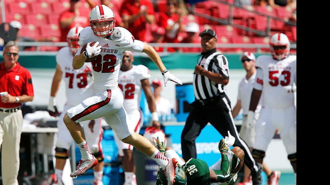 
N.C. State wide receiver Bo Hines (82) gets past South Florida defensive back Nate Godwin (36) during the Wolfpack's game against South Florida at Raymond James Stadium in Tampa, Fla., Saturday, September 13, 2014.
