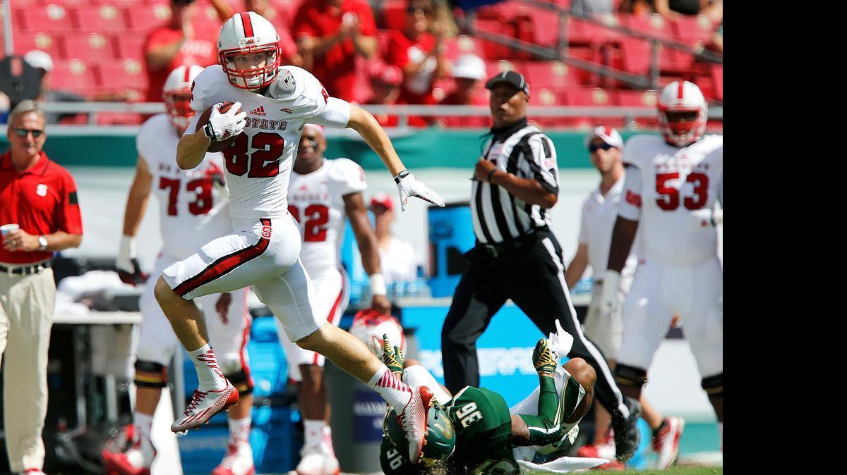 
N.C. State wide receiver Bo Hines (82) gets past South Florida defensive back Nate Godwin (36) during the Wolfpack's game against South Florida at Raymond James Stadium in Tampa, Fla., Saturday, September 13, 2014.
