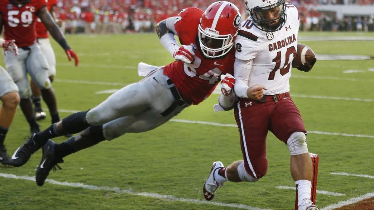 
South Carolina quarterback Perry Orth (10) gets past Georgia linebacker Leonard Floyd (84) to score a touchdown during the first half of an NCAA college football game Saturday in Athens, Ga. 

