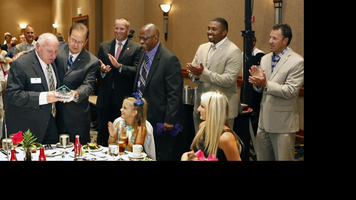 
From left, former UNC-CH head football coach Bill Dooley is presented an award of appreciation by Duke head football coach David Cutcliffe as fellow coaches Dave Doeren from NC State, Ruffin McNeill of East Carolina, Jerry Mack of NC Central, and current coach Larry Fedora of UNC-CH honored Dooley Thursday, July 23, 2014 at the start of the 13th annual Bill Dooley Chapter Pigskin Preview. This year's Pigskin Preview was held at the Embassy Suites Hotel in Cary, NC. Seated at the Dooley family table are Coach Dooley's granddaughter Caroline Dooley and future daughter in law Courtney Holton.

