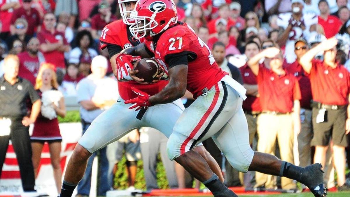 
Georgia running back Nick Chubb (27) takes a handoff from Greyson Lambert to score a second-quarter touchdown against South Carolina on Saturday.


