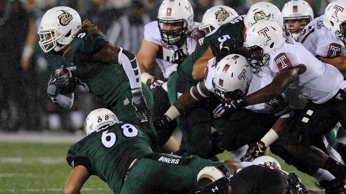 
Charlotte 49ers running back Kalif Phillips, left, breaks free of the Temple Owls defense on a run during first quarter action at Jerry Richardson Stadium on Friday.

