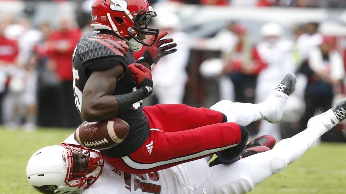 
N.C. State's Jumichael Ramos (85) fumbles while being hit by Louisville cornerback Trumaine Washington (15) during the first half at Carter-Finley Stadium in Raleigh. Louisville would recover the fumble.
