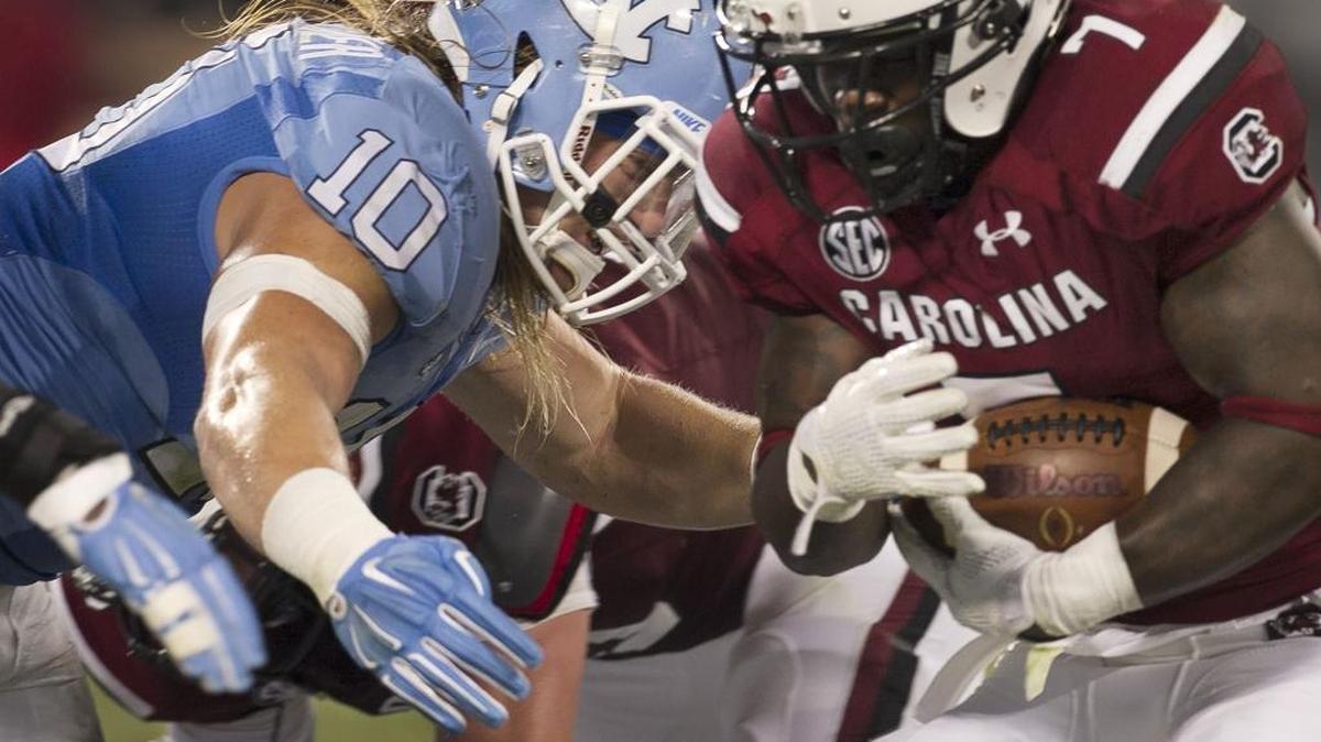 
North Carolina linebacker Jeff Shoettmer (10) stops South Carolina tailback Shon Carson (7) after a gain of 2 yards in the fourth quarter during the Belk College Kickoff at Bank of American Stadium in Charlotte.
