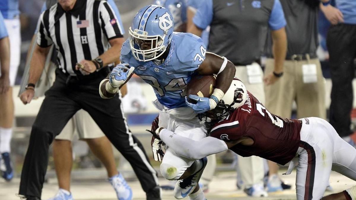 
North Carolina Tar Heels' Elijah Hood (34) powers past South Carolina Gamecocks' Isaiah Johnson (21) during the second half in the Belk College Kickoff season opener at Bank of America Stadium on Thursday, September 3, 2015. South Carolina won 17-13

