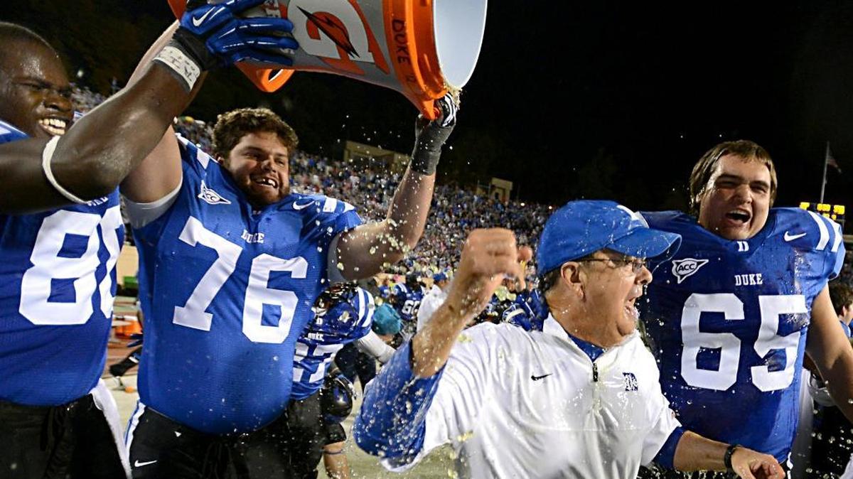 
2012 file – Duke head coach David Cutcliffe heads to celebrate after being doused with Gatorade by Duke tight end David Reeves (80), center Conor Irwin (76) and guard Cody Robinson (65) as Duke beat UNC 33-30 at Wallace Wade Stadium in Durham, October 20, 2012.
