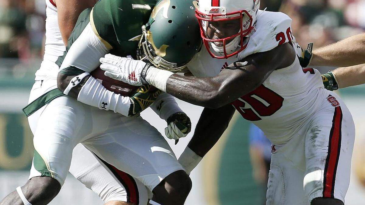 N.C. State's Hakim Jones (20) hits South Florida's Chris Dunkley (1) during the first half of the Wolfpack's game against South Florida at Raymond James Stadium in Tampa, Fla., Saturday, September 13, 2014.