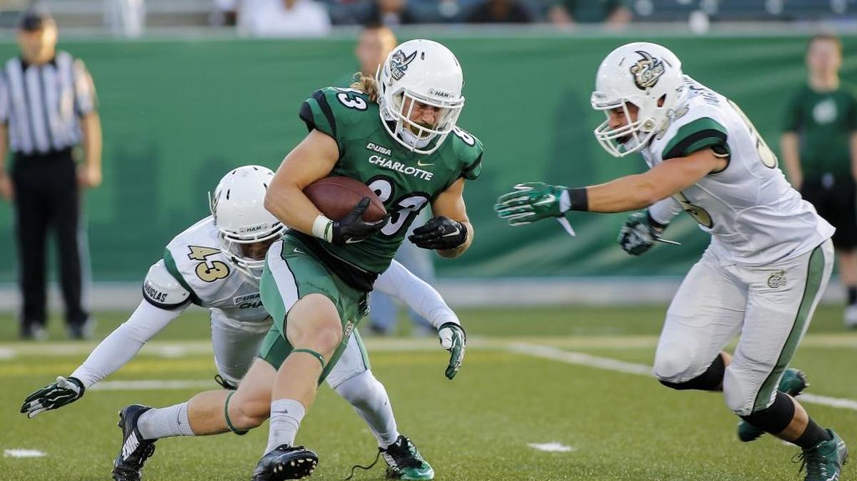 Charlotte 49ers wide receiver Nate Mullen, center, carries the football after a reception in the Green-White football game at Richardson Stadium in Charlotte on Saturday.