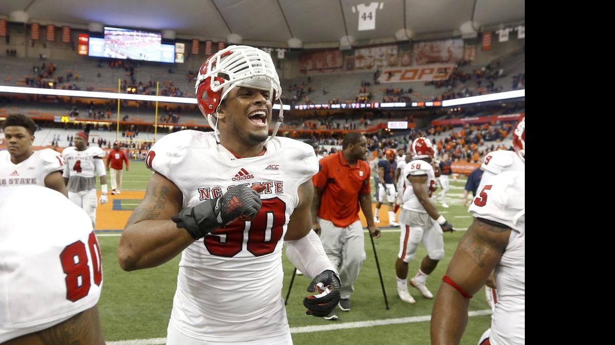 
N.C. State defensive end Mike Rose (90) celebrates as he walks off the field after the Wolfpack 24-17 victory over Syracuse at the Carrier Dome in Syracuse, N.Y., Nov. 1, 2104.
