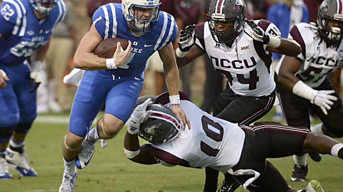 
Duke quarterback Thomas Sirk (1) heads for the end zone to score in the second quarter as NCCU linebacker Jordan Miles (10) and linebacker Kenneth O'Neal (34) attempt to stop him at Wallace Wade Stadium in Durham, N.C. Saturday, September 12, 2015. 
