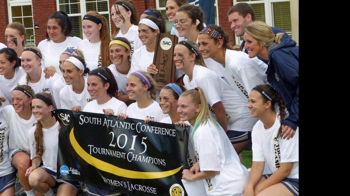 
The players and coaches of Queens' women's lacrosse team pose for photos with the championship trophy and banner after beating Lenoir-Rhyne 20-10 in the South Atlantic Conference tournament final. 
