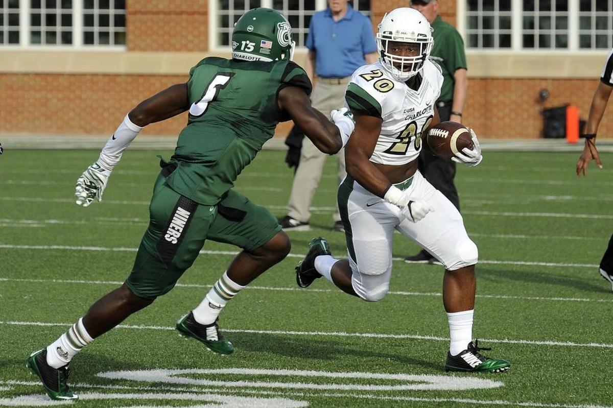 Charlotte 49ers sophomore running back Robert Washington (right) tries to get past sophomore defensive back Marquavis Gibbs during Saturday’s spring football game at Richardson Stadium.