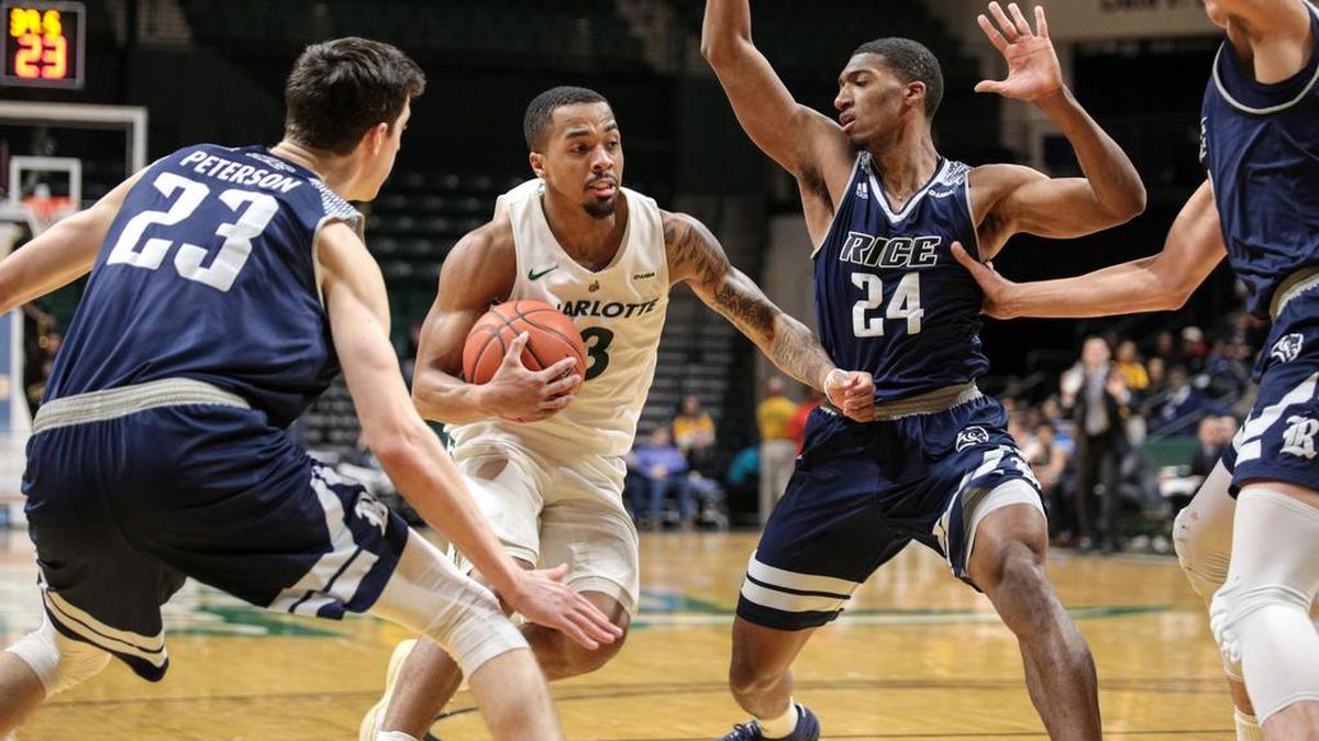 The 49ers’ Jon Davis drives to the basket between Rice defenders Drew Peterson (23) and Chris Mullins (24). Davis finished with 29 points in his home finale.