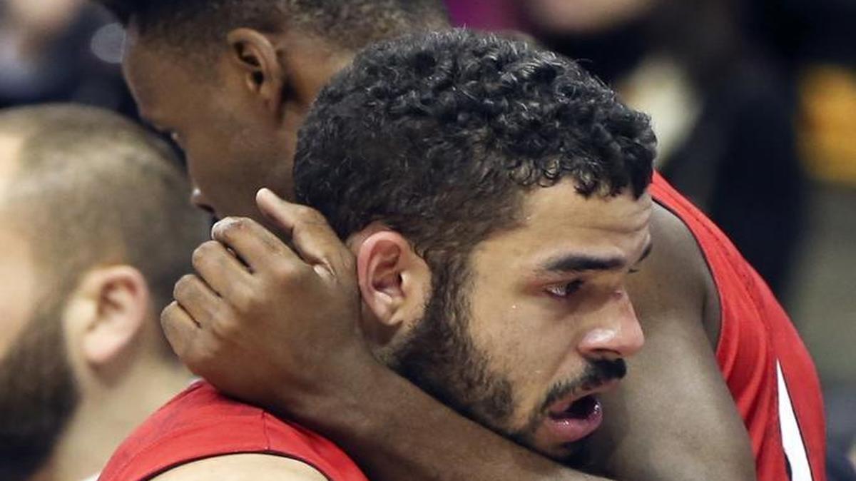 Davidson's Jack Gibbs, front, gets a hug from teammate Nathan Ekwu after leaving Saturday’s game against Rhode Island in the Atlantic 10 tournament semifinals in Pittsburgh. Rhode Island won 84-60 to advance to the championship.