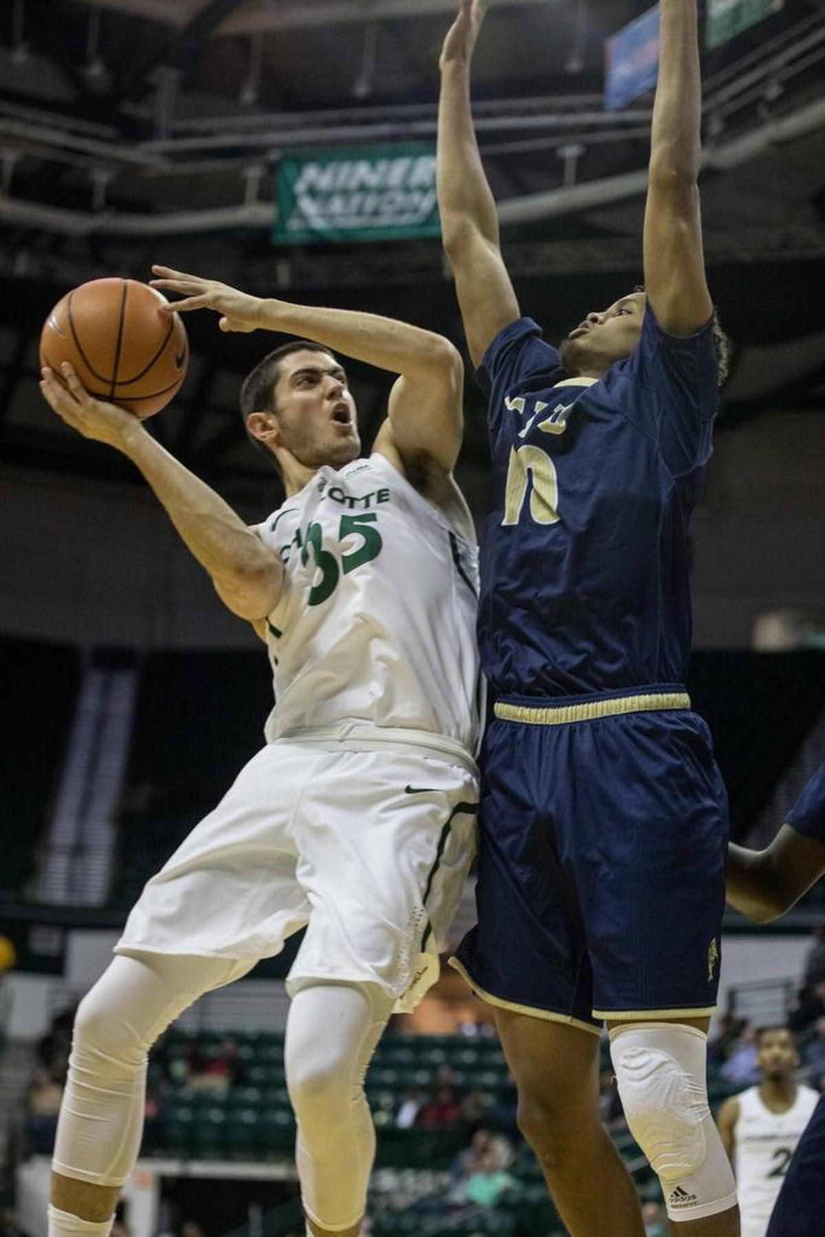 Charlotte freshman guard Luka Vasic (35) works against Florida International forward Hassan Hussein in Thursday’s game.