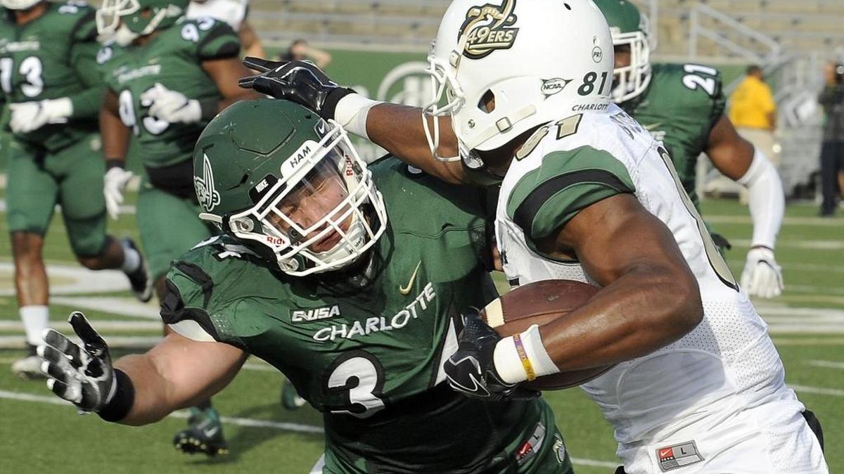 Charlotte 49ers redshirt senior wide receiver Trent Bostick, right, stiff-arms redshirt sophomore linebacker Jeff Gemmell during Saturday’s spring football game at Richardson Stadium.