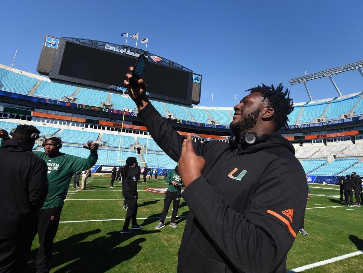 Miami’s Navaughn Donaldson takes photos during the Hurricanes’ walk through at Bank of America Stadium, site of Saturday night’s ACC football championship game. Miami will face Clemson, which has won the past two titles.