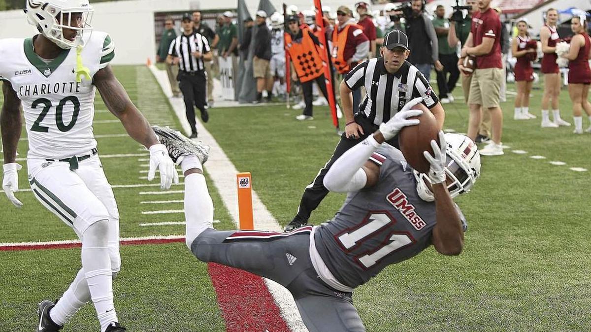 Massachusetts’ Zak Simon makes a diving catch in the end zone in front of Charlotte’s DJ Anderson as an official looks to confirm the catch for a touchdown during the second quarter of Saturday’s college football game in Amherst, Mass.