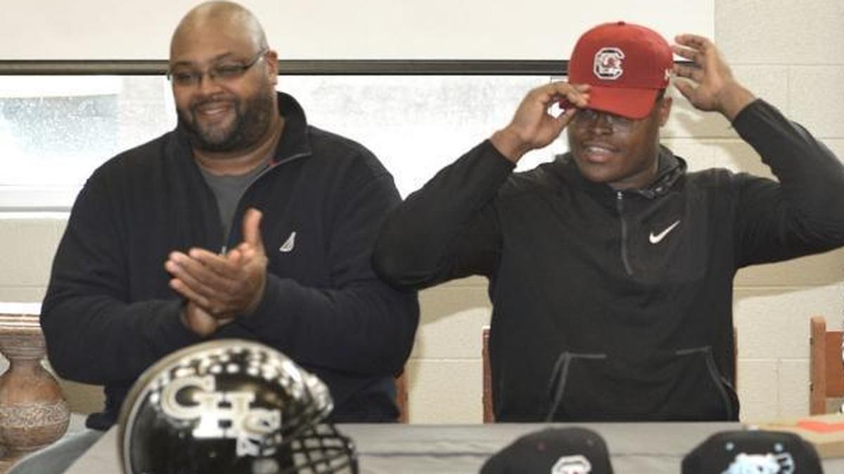 Concord High lineman Rick Sandidge (right), sitting next to his father, Rick Sandidge Sr., announced that he will play football for the South Carolina Gamecocks.