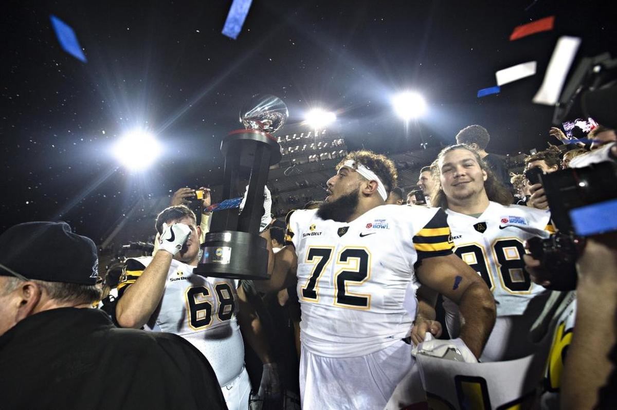 Appalachian State defensive lineman Tyson Fernandez (72) holds the trophy after the Mountaineers beat Toledo 31-28 in Saturday’s Camellia Bowl in in Montgomery, Ala.