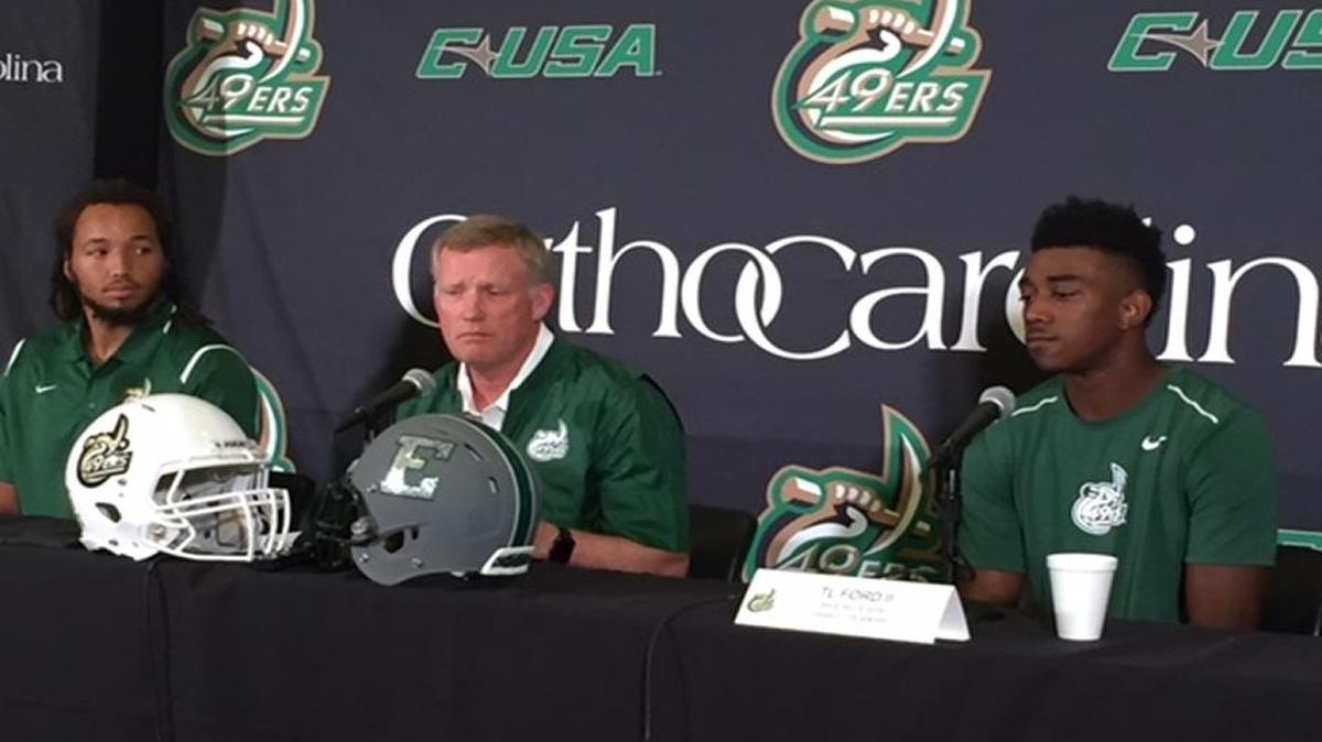 Charlotte 49ers’ coach Brad Lambert (center) meets with the media Tuesday. He is flanked by linebacker Tyriq Harris (left) and wide receiver T.L. Ford II (right).