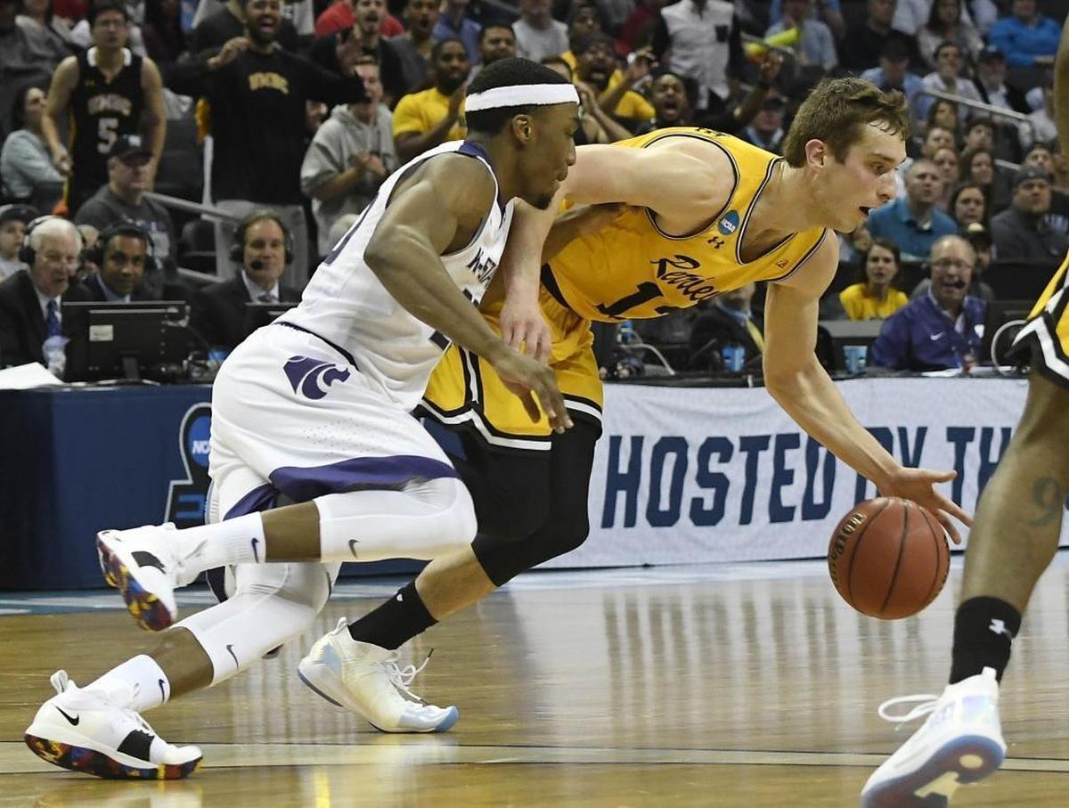 UMBC Retrievers forward Joe Sherburne (13) recovers a loose ball as Kansas State Wildcats forward Xavier Sneed (20) closes in during Sunday’s second-round NCAA tournament game at the Spectrum Center.
