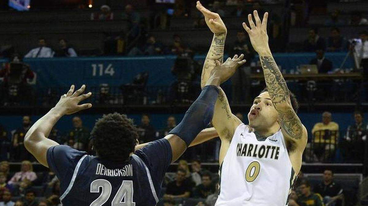 Charlotte 49ers Ridell Camidge on right, shoots over Georgetown's Marcus Derrickson during Tuesday night's game played against Georgetown at Time Warner Cable Arena Dec 22, 2015.