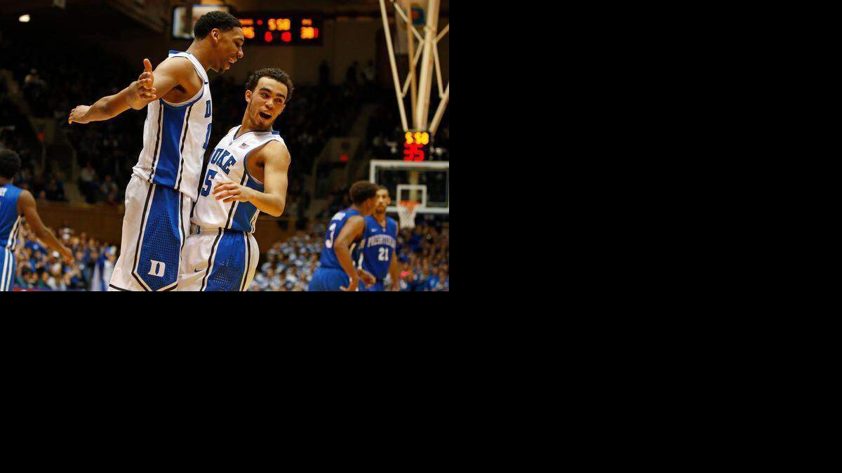 
Duke's Jahlil Okafor (15) celebrates with teammate Tyus Jones (5) during the second half of an NCAA college basketball game against Presbyterian in Durham, Friday, Nov. 14, 2014. Okafor had 19 points and Jones added 15 in Duke's 113-44 win. 
