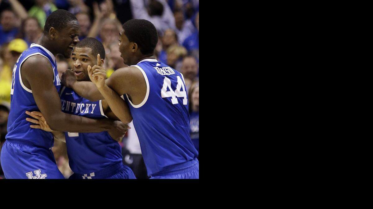 
Kentucky's Aaron Harrison is congratulated by teammates Julius Randle and Dakari Johnson (44) after making a 3-point basket in the final seconds of the second half of an NCAA Midwest Regional final college basketball tournament game against Michigan Sunday, March 30, 2014, in Indianapolis. Kentucky won 75-72 to advance to the Final Four. 

