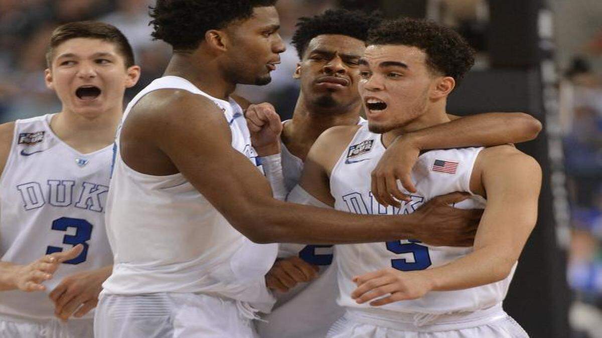 
Duke’s Grayson Allen (3), Justise Winslow, Quinn Cook (2) surround guard Tyus Jones (5) after he is fouled in the first half of play against Michigan State during the semifinal game of the NCAA Final Four at Lucas Oil Stadium in Indianapolis.
