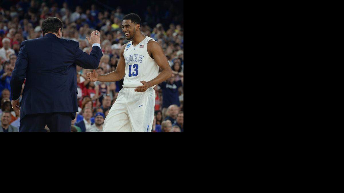 
Duke head coach Mike Krzyzewski greets guard Matt Jones (13) as he heads towards the bench near games end against Gonzaga . Duke beat Gonzaga 66-52 for a berth in the Final Four at the NCAA South Region Sunday, March 29, 2015 at the NRG Stadium in Houston, Texas. 

