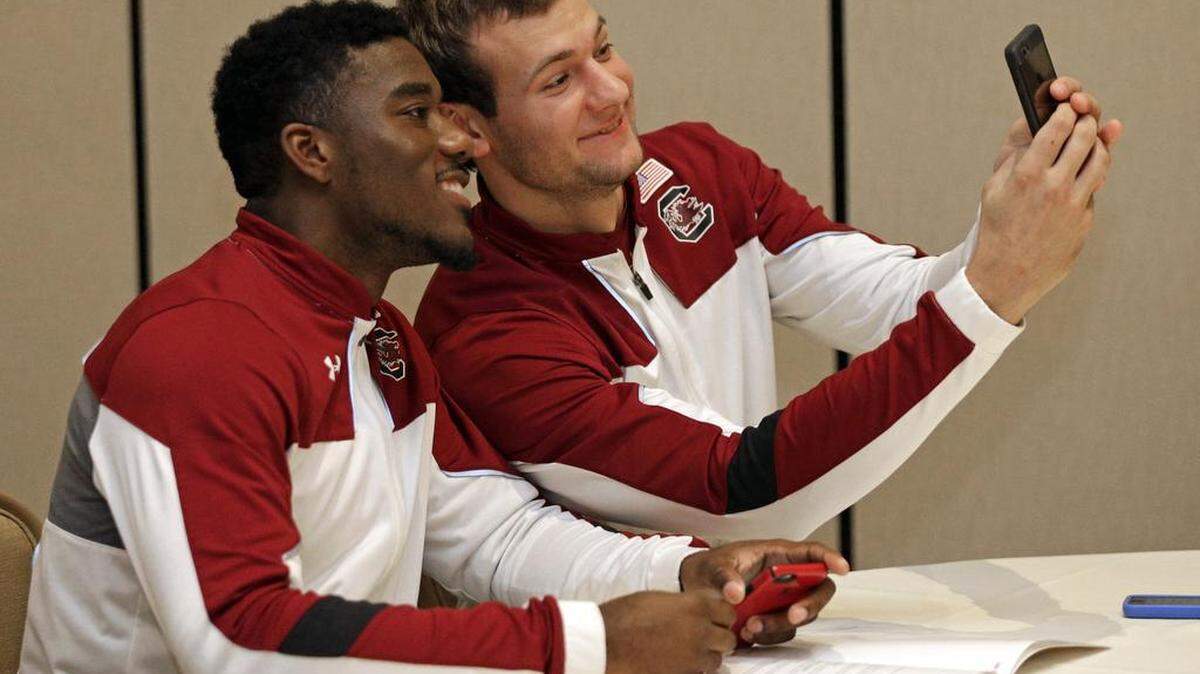 South Carolina's Duane Notice, left, and Mindaugas Kacinas take a selfie during Wednesday’s SEC basketball media day in Charlotte. .
