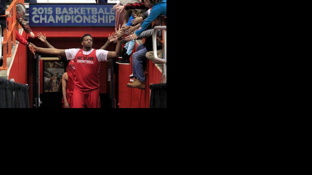 
N.C. State's BeeJay Anya (21) greets fans as he comes onto the court before practice for the 2015 NCAA Men's Basketball East Regionals at the Carrier Dome in Syracuse, N.Y., Thursday, March 26, 2015. The Wolfpack will face Louisville on Friday. 
