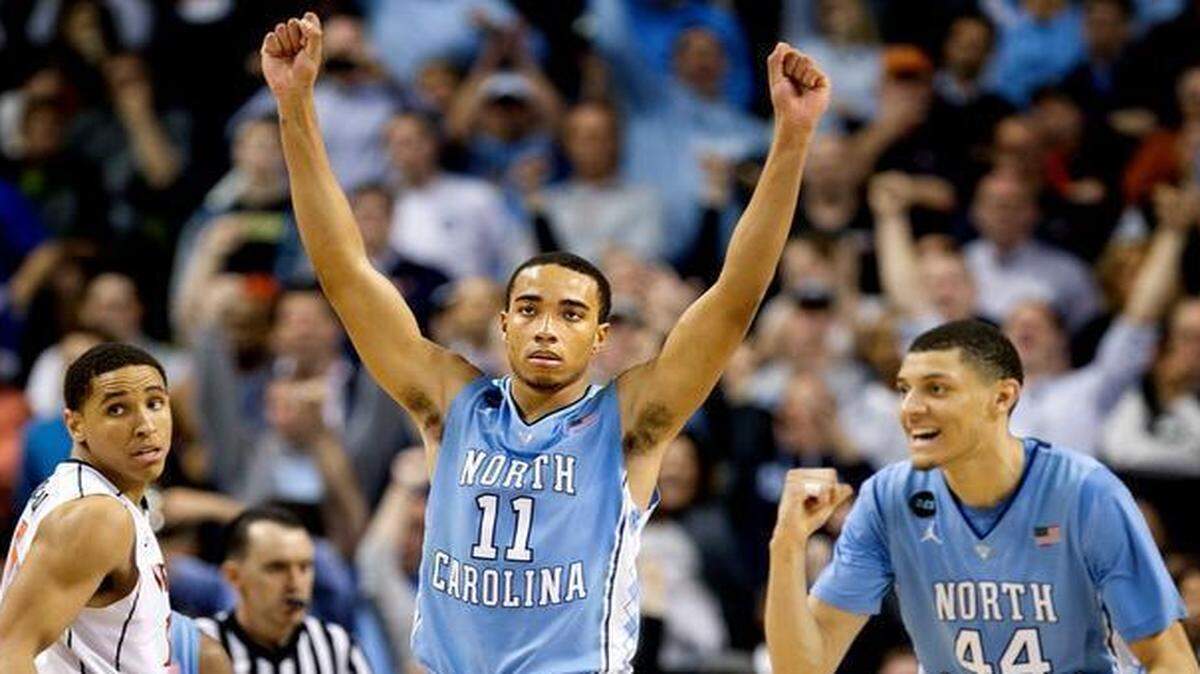 Virginia’s Malcolm Brogdon (15) leaves the court as North Carolina’s Brice Johnson (11) and Justin Jackson (44) celebrate the Tar Heels’ 71-67 victory over the Cavaliers <137>Virginia <137>on Friday, March 13, 2015 in the semifinals of the ACC<137>Atlantic Coast Conference<137> Basketball Tournament at the Greensboro Coliseum<137> in Greensboro, N.C<137>.