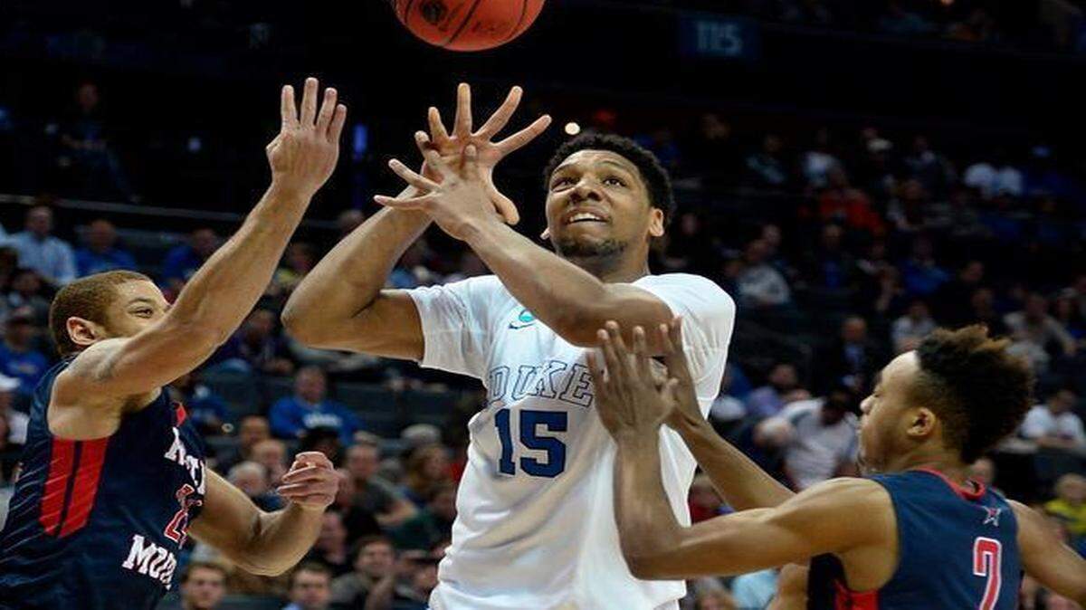 
Duke's Jahlil Okafor (15) looks to regain control of a bobbled ball as Robert Morris' Aaron Tate (24) and Marcquise Reed (2) apply defensive pressure during the 2015 NCAA Division I Men's Second Round Basketball Championship action at Time Warner Cable Arena in Charlotte on Friday March 20, 2015.
