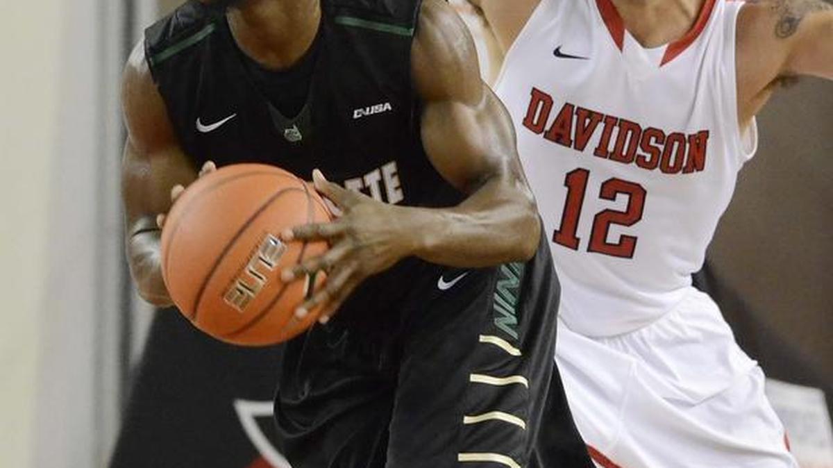 Charlotte 49ers Braxton Ogbueze drives the ball away from Davidson’s Jack Gibbs during a game played at Davidson’s Belk Arena on Dec. 3, 2014.