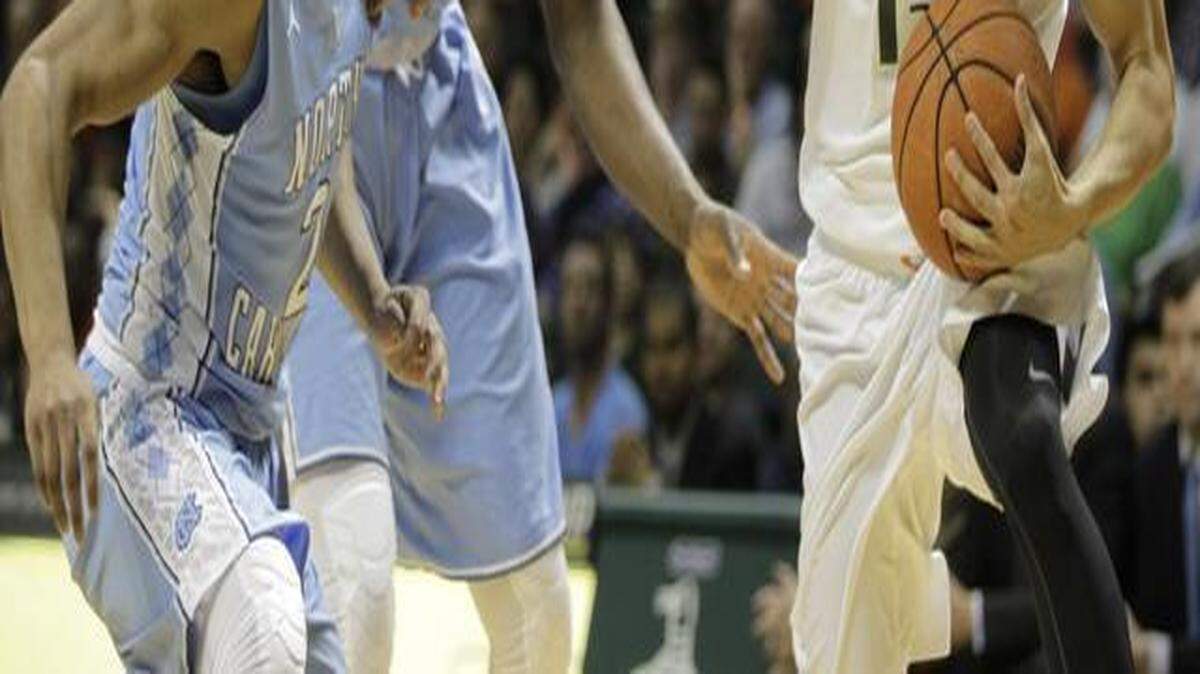 
Miami’s Angel Rodriguez, right, move the ball past North Carolina’s Joel Berry II (2) and Joel James (42) during the first half of an NCAA college basketball game, Saturday, Feb. 28, 2015, in Coral Gables, Fla. 
