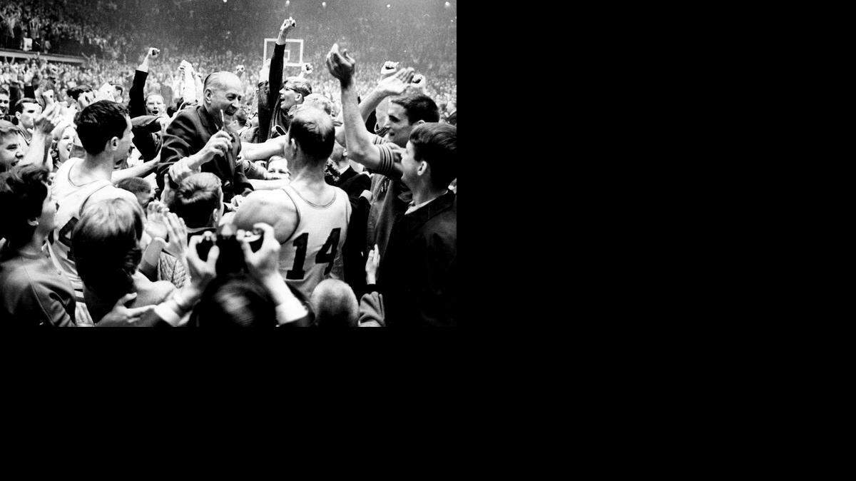 
Everett Case, center, is lifted aloft by players and fans following N.C. State's 1965 ACC tournament title win.
